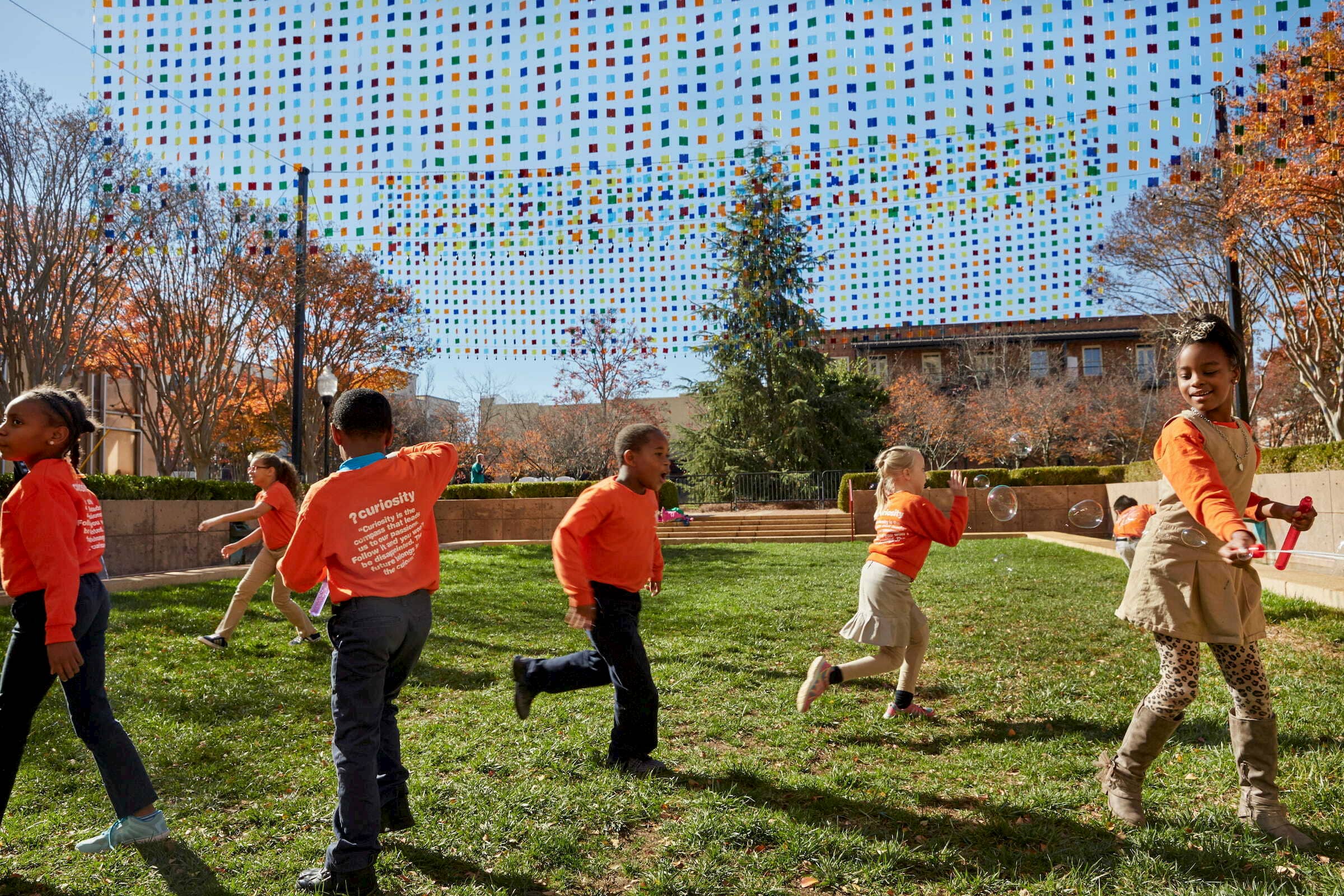 Image: Children running around a public art installation, Bloomberg Philanthropies, Evaluating the Impact of Public Art Across America